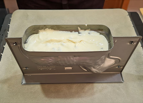 Eine mit Teig befüllte Osterlamm-Kuchenform.
